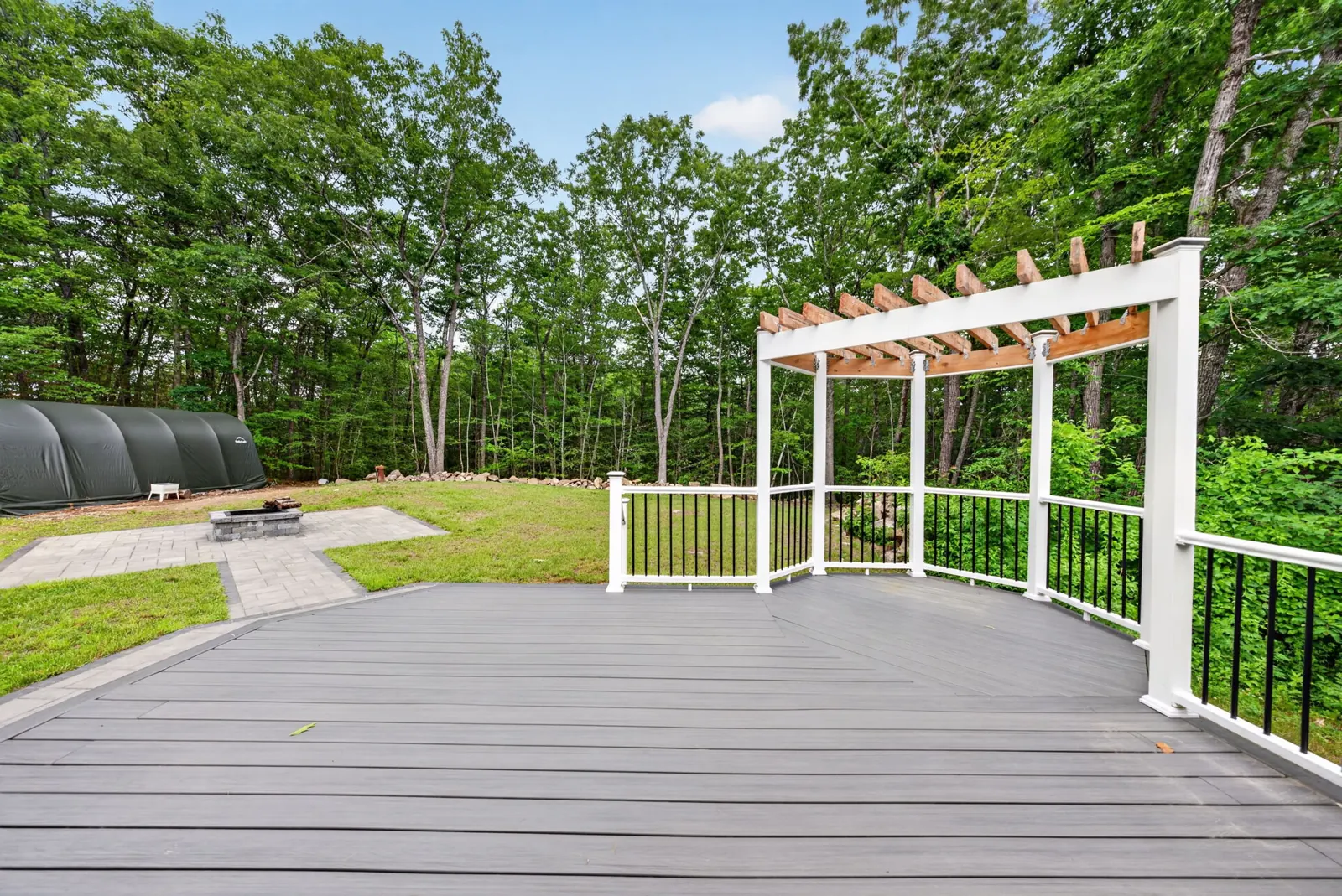 Composite deck with pergola overlooking the yard at an Alton, NH home