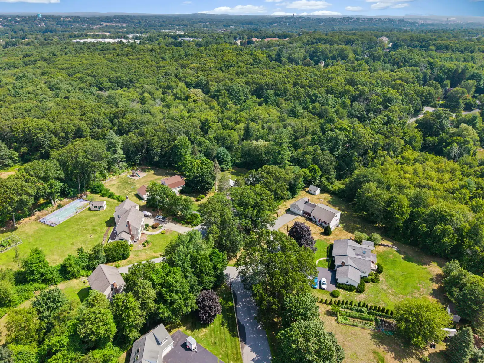 Drone aerial view of a home and wooded neighborhood on Mercury Cir in Andover, MA