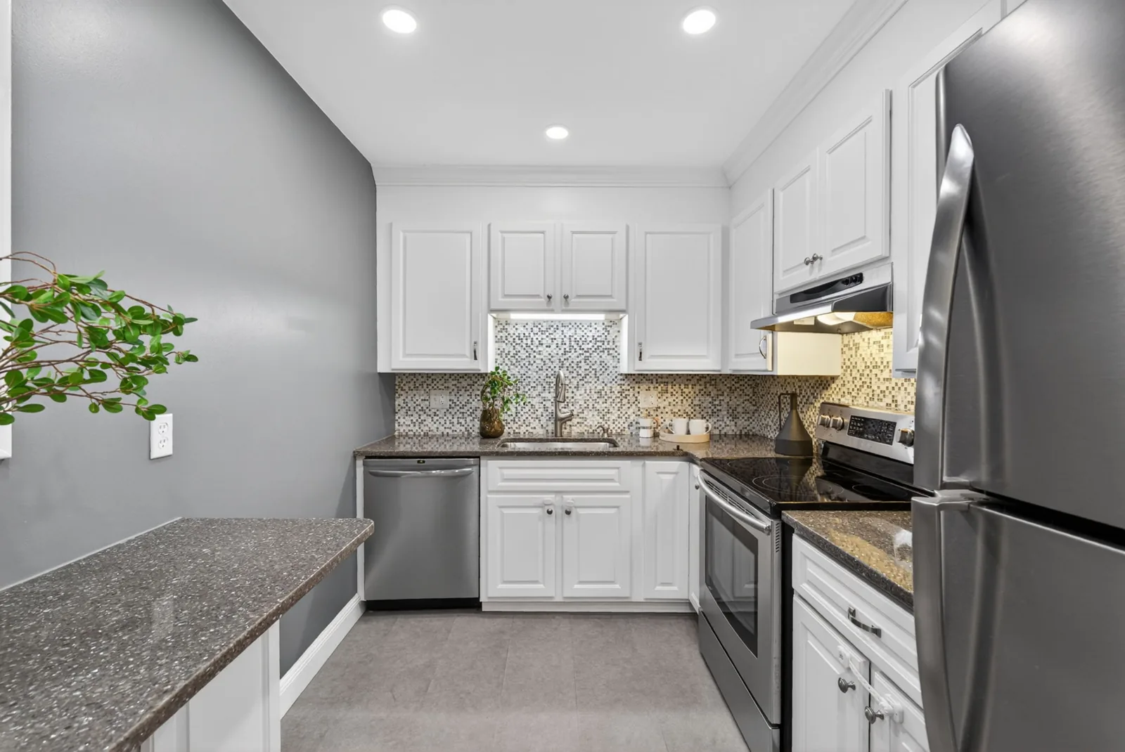 Kitchen with white cabinets and stainless appliances in a Brookline, MA condo