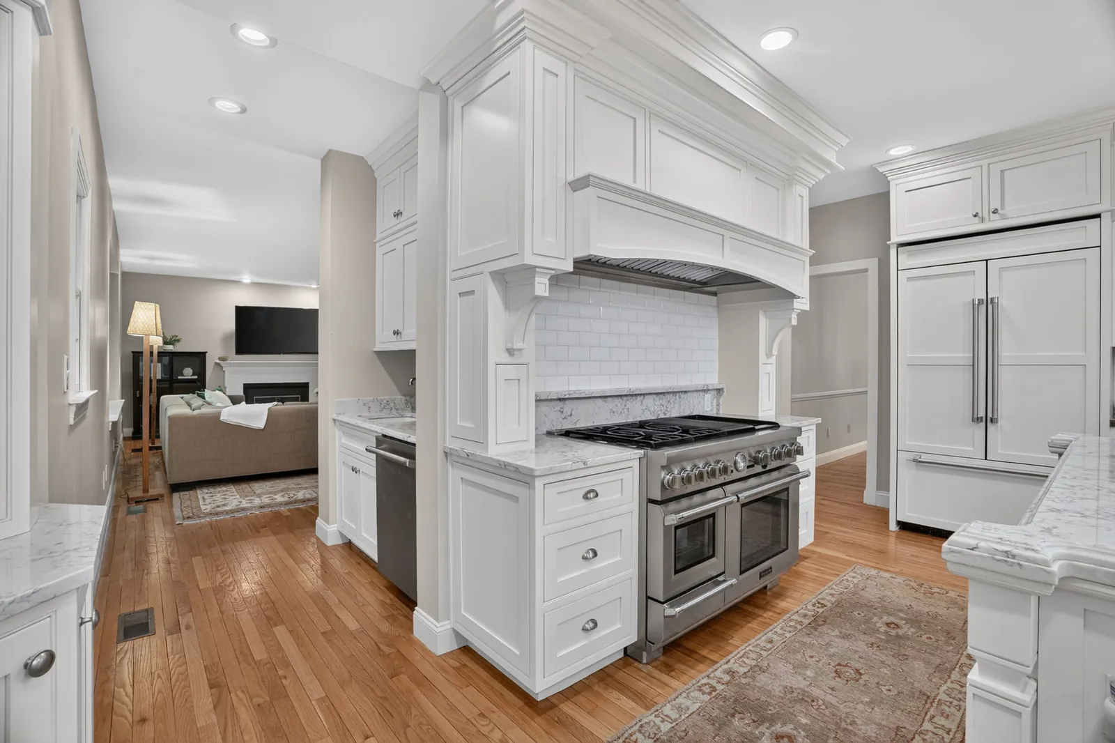 White chef's kitchen with large center island and range in a Hopkinton, MA home