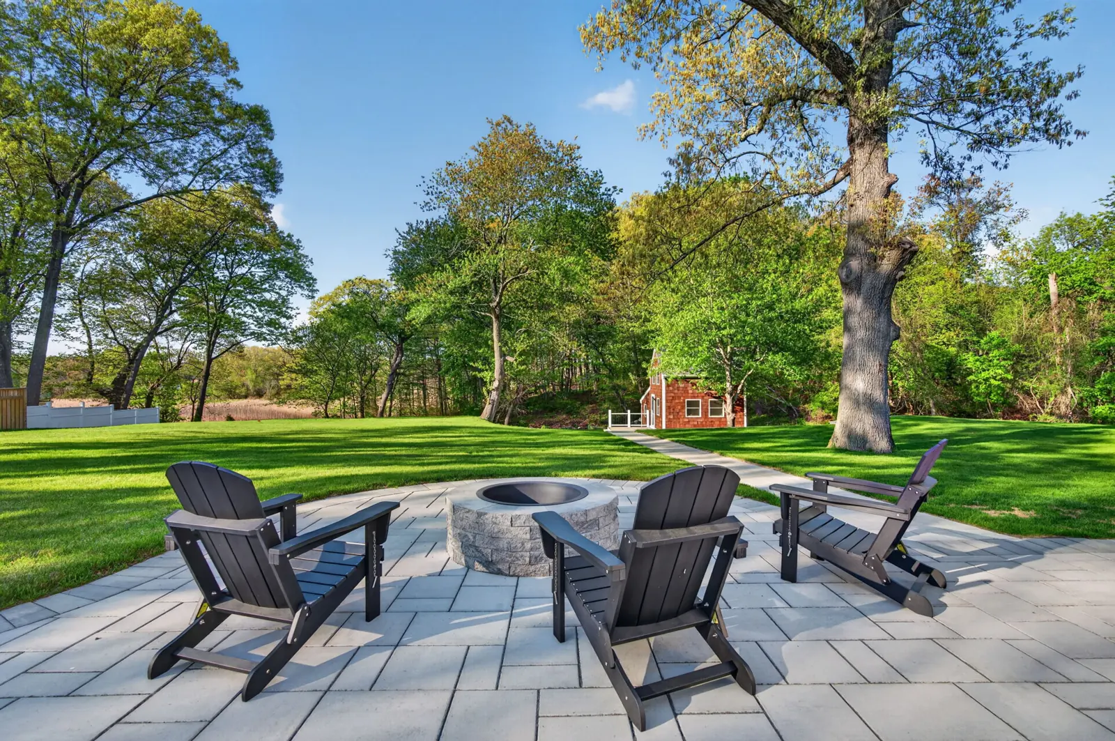 Stone patio with fire pit and Adirondack chairs at a Newburyport, MA home
