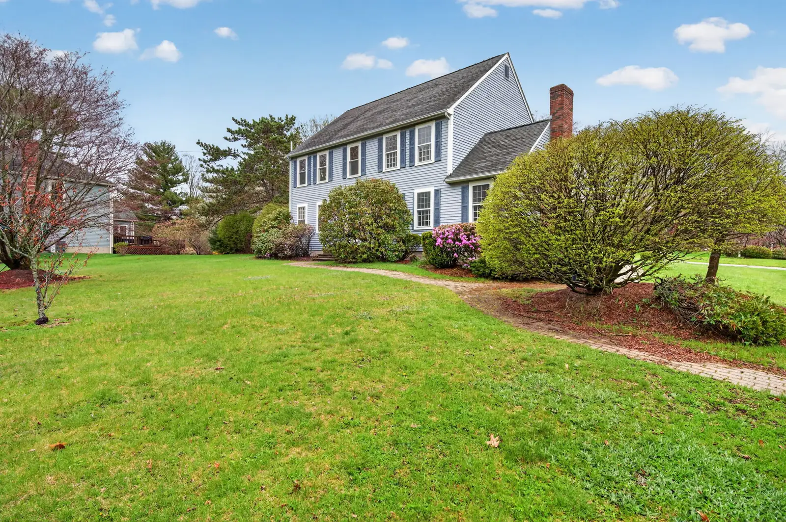 Front exterior of a Colonial with two-car garage on Olympic Ln in North Andover, MA
