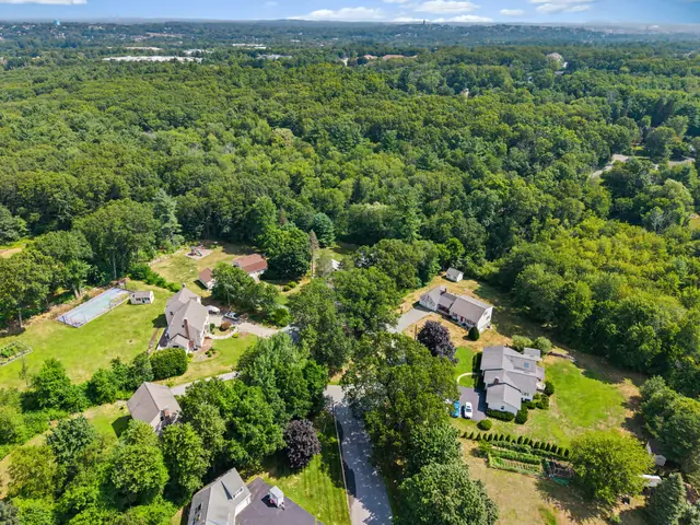 Drone aerial view of a home and wooded neighborhood on Mercury Cir in Andover, MA