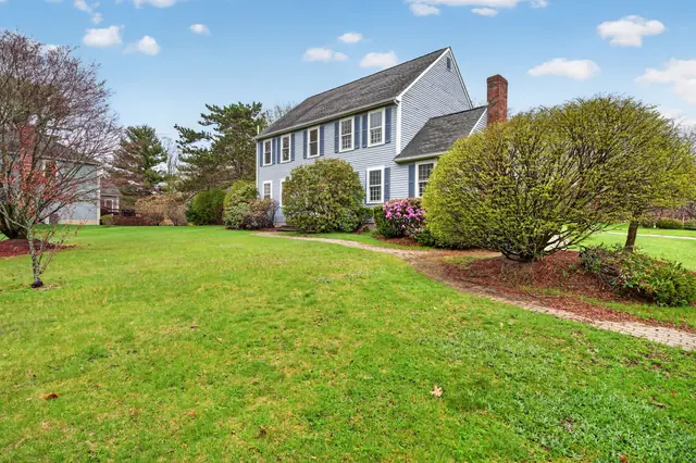 Front exterior of a Colonial with two-car garage on Olympic Ln in North Andover, MA