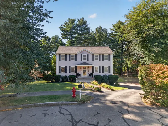 Front exterior and landscaped lawn of a colonial home on Kristyn Ln in North Reading, MA