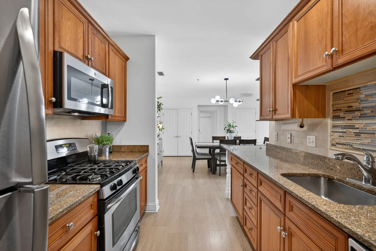 Condo kitchen with wood cabinets and granite counters in Wakefield, MA